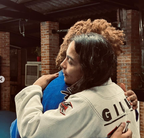 Giulia Geovana recebendo o abraço de uma aluna
